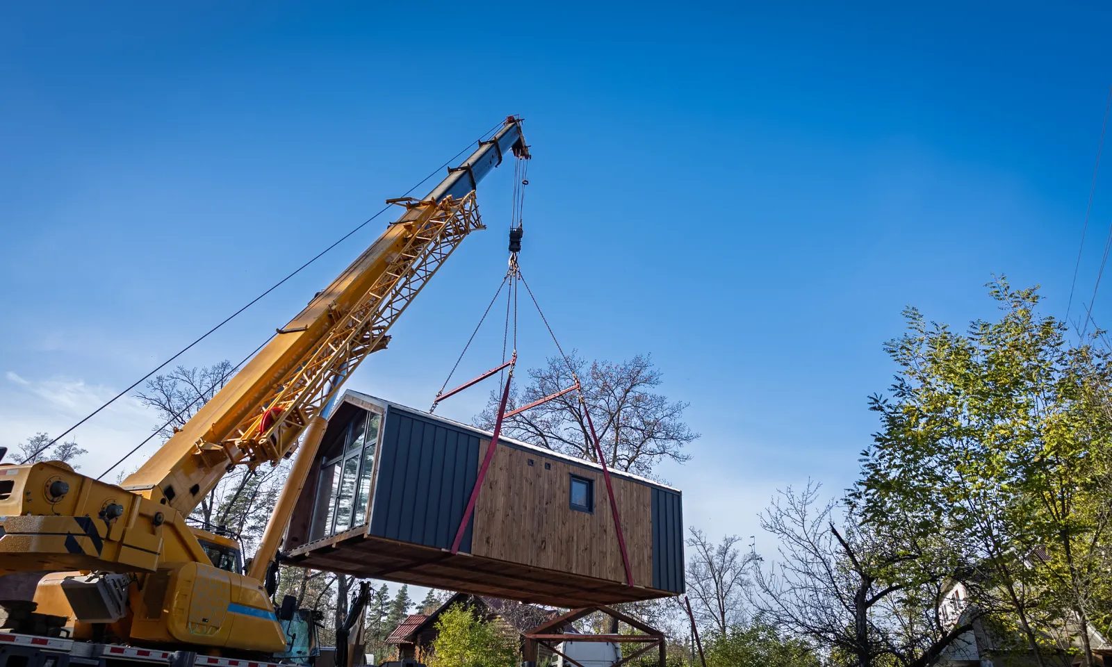 Crane installing prefabricated ADU unit in Los Angeles backyard during modular accessory dwelling unit placement